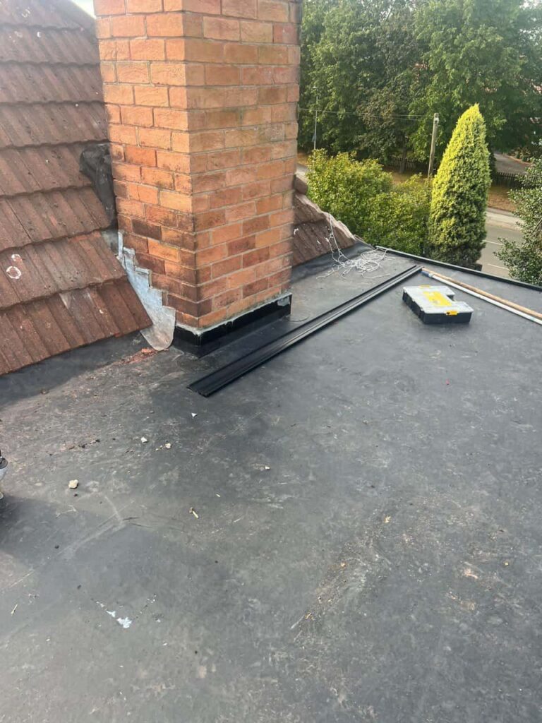 This is a photo of a flat roof which has just been repaired, there is also a chimney stack and some leadwork has also been dressed. Works carried out by Hurstpierpoint Roofing Repairs