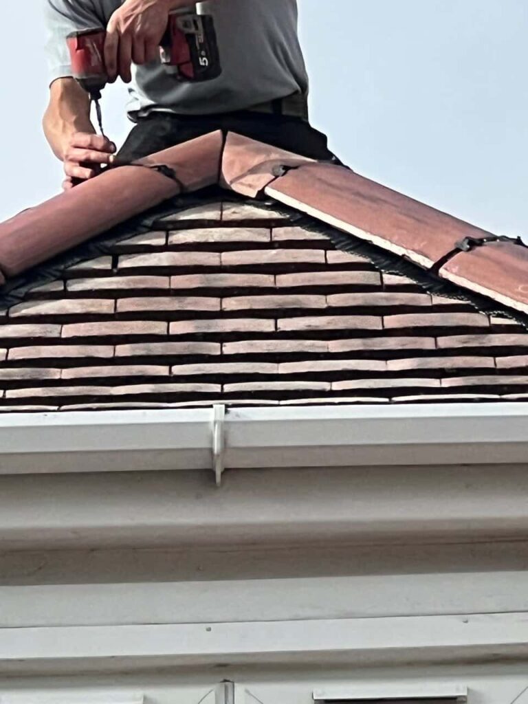 This is a photo of one of the operatives of Hurstpierpoint Roofing Repairs installing new ridge tiles